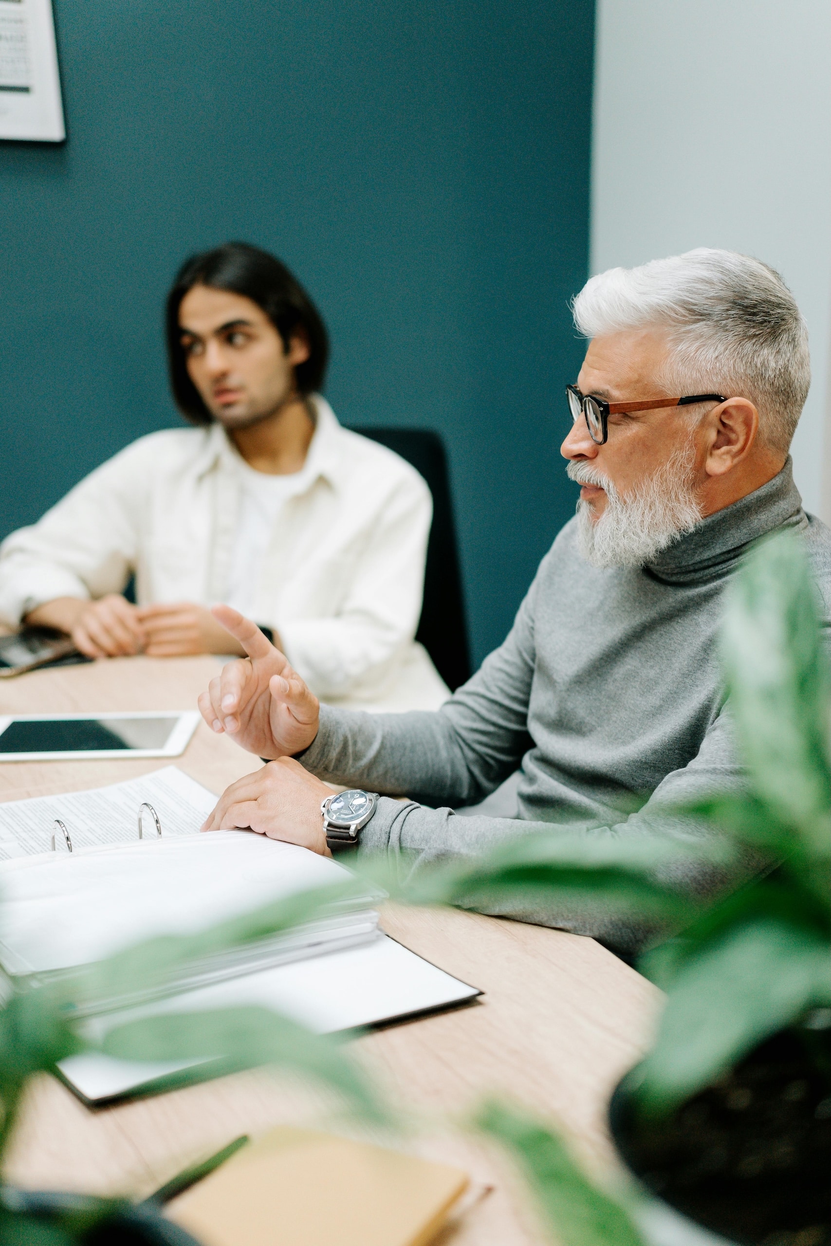 Senior business leader mentoring a younger successor during a meeting – representing family business succession, governance and HR consulting in Malta.